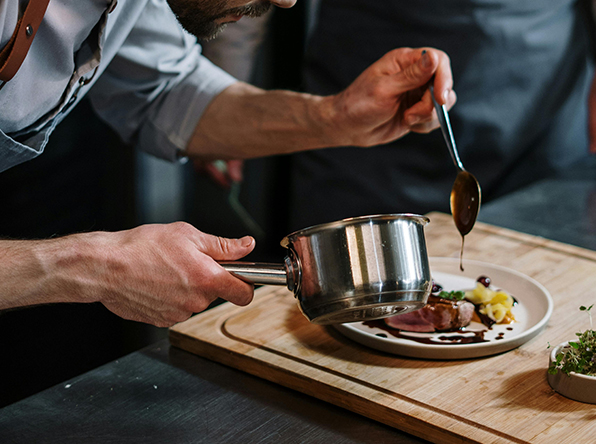 Hands plating a dish